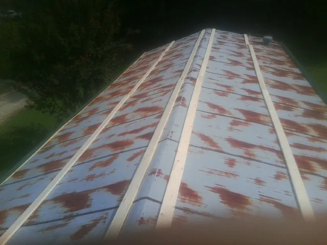 Rusted metal roof panels with new wood purlins before replacement — Storm Damage Roof Repair in Lamont by Roofing Brothers
