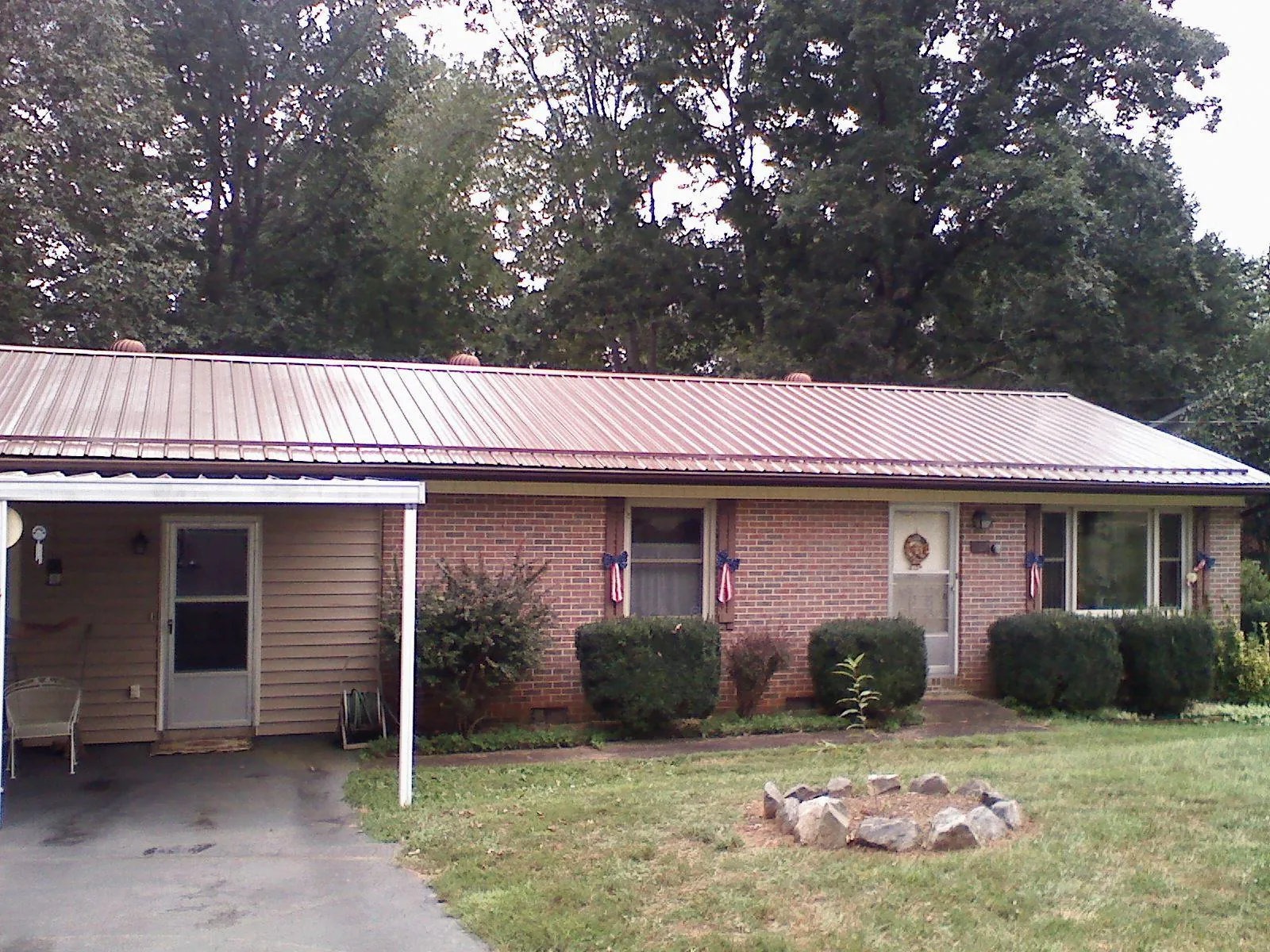 Bronze metal roof and carport on a brick ranch home — Roof Repair work by our crew in Lamont