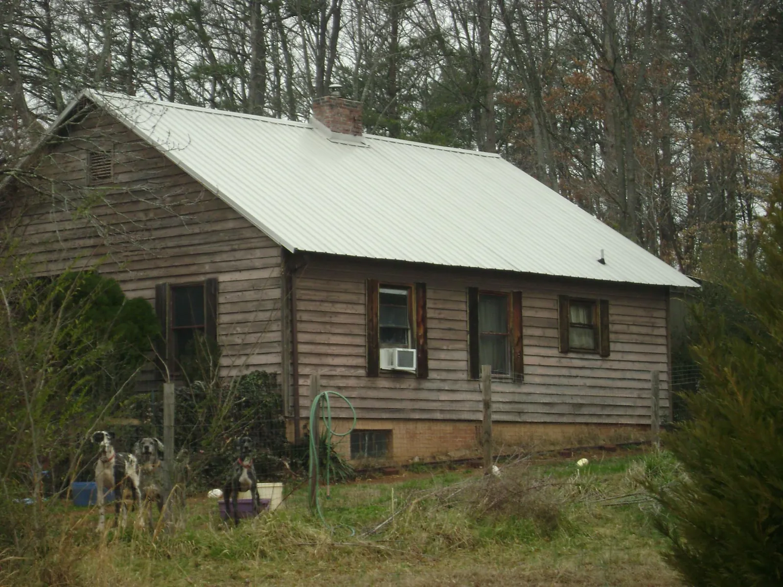 White metal roof on an old wood sided farmhouse, from a Metal Roof Installation job in Lamont